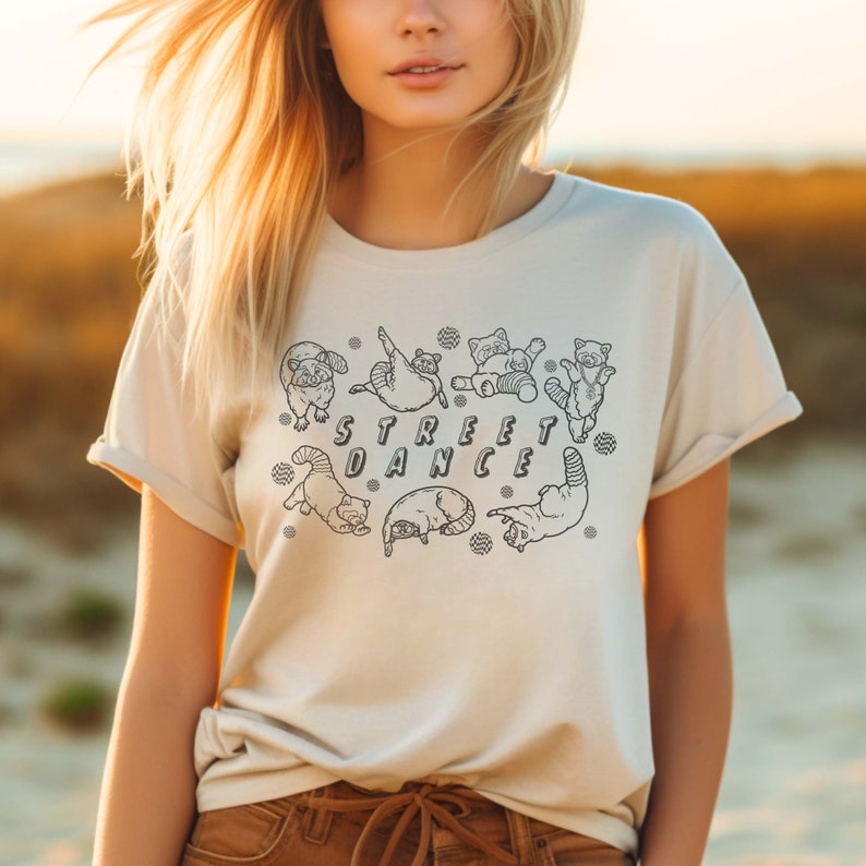 May include: A white t-shirt with a black line drawing of red pandas dancing around the words "STREET DANCE".