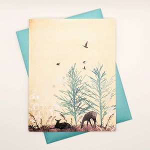 May include: A greeting card with a nature scene featuring deer, trees, and birds in flight. The card has a cream-coloured background with teal trees and a teal envelope. The words "PEACE EARTH" are printed on the card.