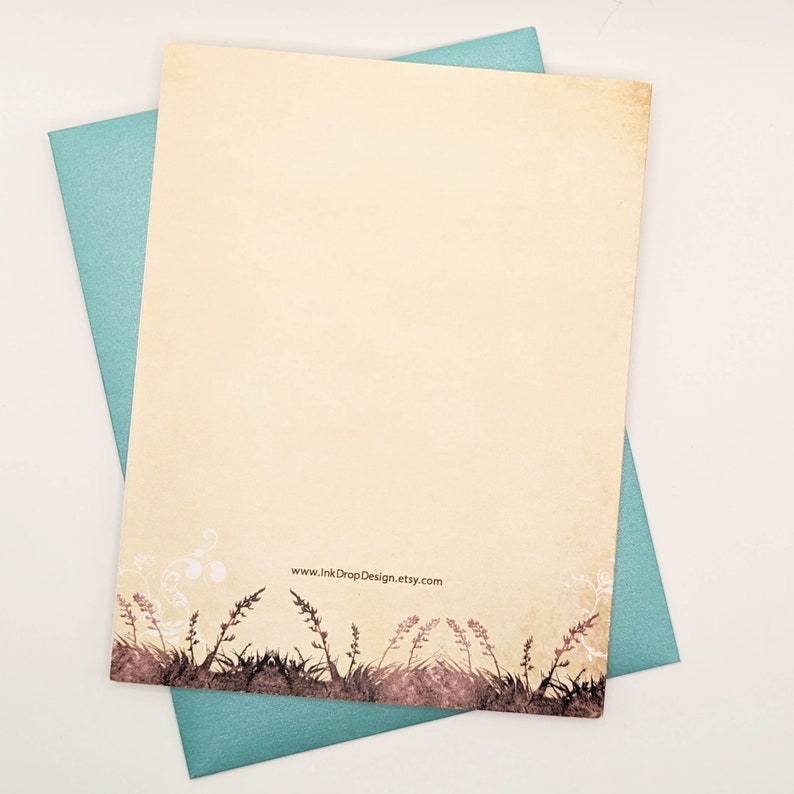 May include: A cream-coloured stationery sheet with a floral border and a teal envelope. The stationery has a vintage aesthetic with a decorative border of brown grass and flowers. The website address www.InkDropDesign.etsy.com is printed on the stationery.