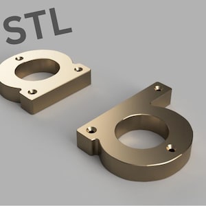 May include: Two gold-colored metal letters, "D" and "O", with a hole in the center of each letter. The letters are designed to be mounted on a surface.