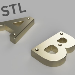 May include: Two gold-colored metal letters, A and B, with holes for mounting. The letters are in a 3D style and have a slightly rounded appearance. The letters are on a gray background.