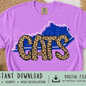 May include: A lilac t-shirt with the word "CATS" in a leopard print font, set against a blue state outline. The shirt has rolled sleeves and a crew neck. The words "INSTANT DOWNLOAD" are at the bottom of the image.