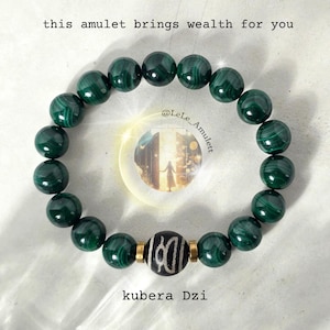 Peut inclure: Bracelet de perles en malachite vert foncé. Il comprend une perle centrale Kubera Dzi avec un motif noir et blanc, et des entretoises dorées. Le texte sur l'image indique : "this amulet brings wealth for you."