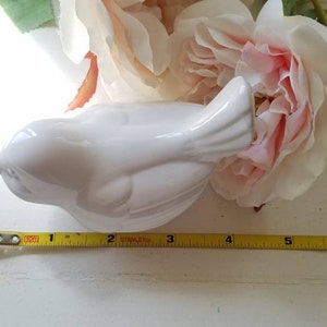 May include: White ceramic bird figurine with a detailed tail and a smooth, glossy finish. The bird is approximately 5 inches long.
