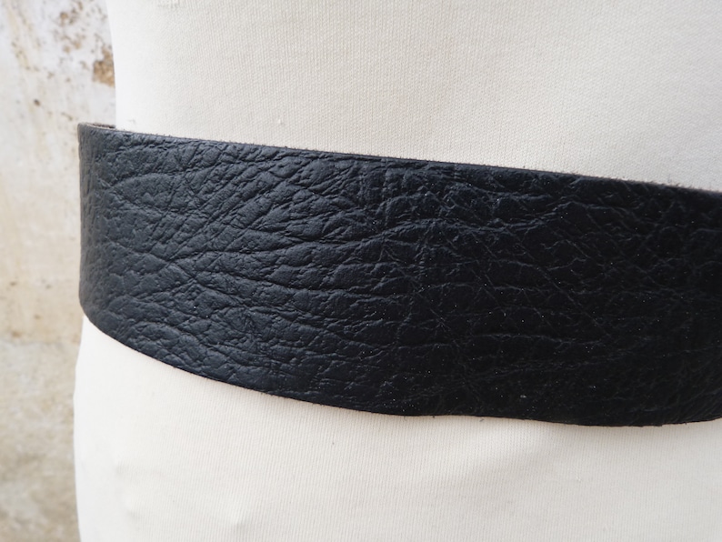 May include: A wide black leather belt with a textured surface.