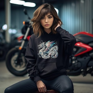 May include: Black hoodie with a colorful dragon graphic print. The dragon is detailed with intricate patterns and has a blue, purple, and pink color scheme.