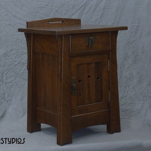 May include: A dark brown wooden nightstand with a single drawer and a cabinet door. The cabinet door has a decorative design with three cutouts. The nightstand has a simple, elegant design.