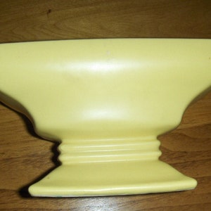 Mc Coy vase in a soft buttery yellow.The second picture is closer to the color. From the 30,s image 1
