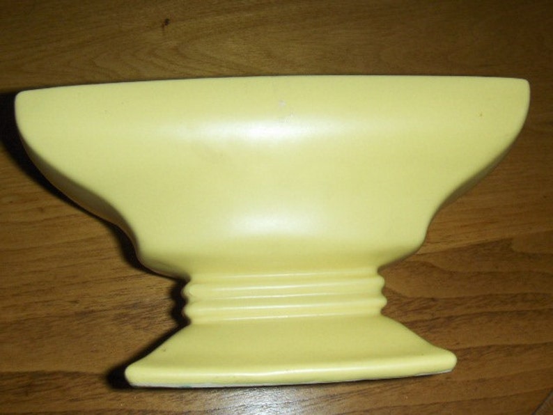 Mc Coy vase in a soft buttery yellow.The second picture is closer to the color. From the 30,s image 1