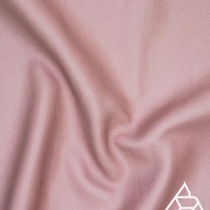 May include: A close-up of a soft, pink, textured fabric. The fabric has a subtle sheen and a slightly wrinkled appearance.