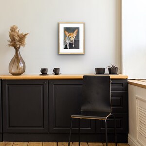 May include: A framed painting of a small, white and brown dog with brown ears sitting on a gray background. The dog is looking directly at the viewer.