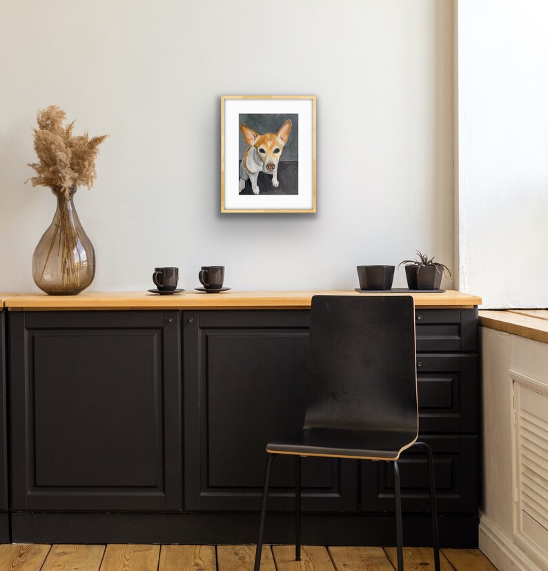 May include: A framed painting of a small, white and brown dog with brown ears sitting on a gray background. The dog is looking directly at the viewer.