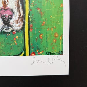 May include: A print featuring a close-up of a dog's snout with a pink nose and brown markings. The background is a vibrant green with a pattern of small orange flowers and thin yellow lines. The name Susannah and a signature are visible at the bottom.