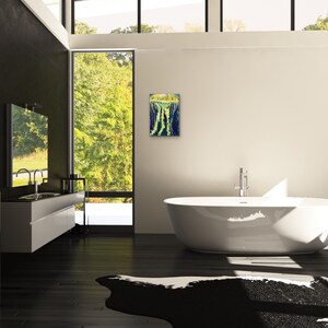 May include: A modern bathroom with a white bathtub, a black and white cowhide rug, and a framed abstract painting on the wall.