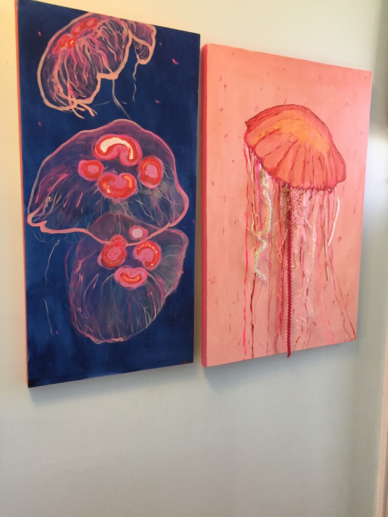 May include: Two paintings of jellyfish, one with a blue background and two jellyfish, the other with a pink background and one jellyfish.