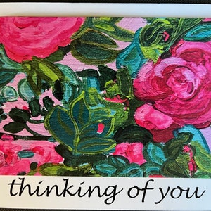 May include: A pink and green floral greeting card with the text "thinking of you" in black cursive writing.