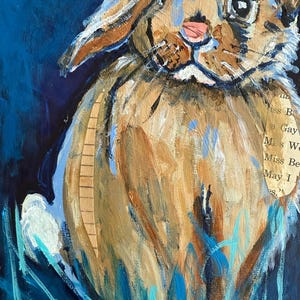 May include: A mixed media painting of a rabbit with brown fur, blue accents, and a pink nose. The rabbit is set against a dark blue background with blue and turquoise brushstrokes suggesting grass. A piece of paper with text is collaged on the rabbit.