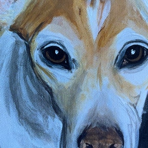 May include: Close-up of a dog's face, painted in a realistic style. The dog has brown and white fur, with brown eyes and a brown nose. The painting is done on a canvas.