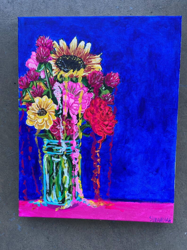 May include: A painting of a bouquet of flowers in a mason jar. The flowers are a mix of pink, red, yellow, and orange. The background is a deep blue. The painting is signed "Sutayah" in the bottom right corner.