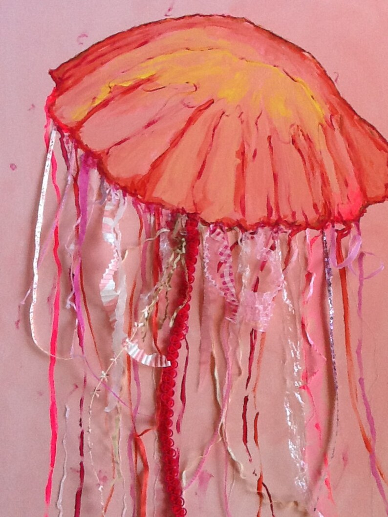 May include: A pink and red jellyfish with long, flowing tentacles made of pink, red, and white ribbons. The jellyfish is painted on a pink background.