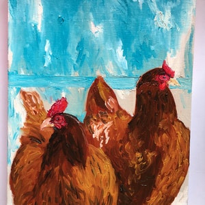 Op de afbeelding: Een schilderij van drie bruine kippen met rode kammen tegen een blauwe achtergrond.