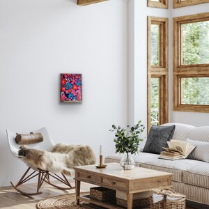 May include: A framed artwork featuring a vibrant floral pattern with pink, red, and blue flowers on a dark background.