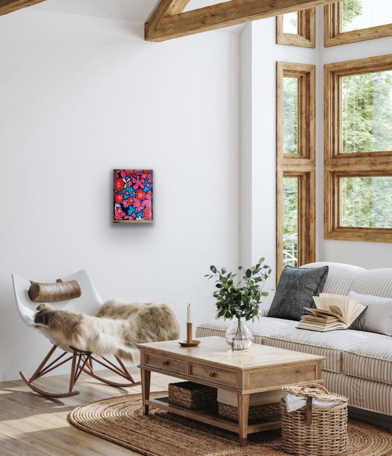 May include: A framed artwork featuring a vibrant floral pattern with pink, red, and blue flowers on a dark background.