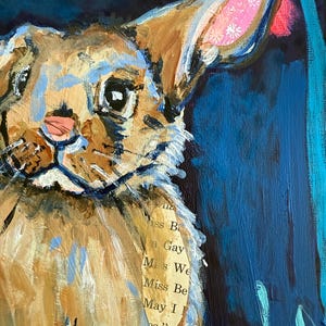 May include: An acrylic painting of a rabbit's head, featuring brown, blue, and pink hues. The rabbit's ear has a patterned interior. A piece of paper with text is collaged onto the rabbit's fur. The background is dark blue with red and turquoise accents.