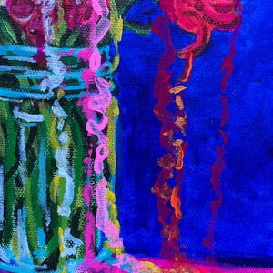 May include: A close-up of a colorful painting of flowers in a glass jar. The flowers are pink, red, and yellow. The jar is green and white. The background is blue.