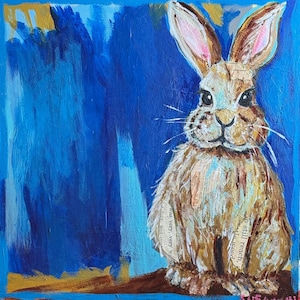 Peut inclure: Peinture originale d'un lapin brun aux longues oreilles et au corps duveteux. Le lapin est pos&eacute; sur un fond bleu avec des coups de pinceau. La fourrure du lapin incorpore des morceaux de papier avec du texte. La peinture est sign&eacute;e en bas &agrave; droite.