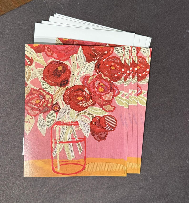 May include: A stack of greeting cards featuring a floral design. The cards showcase a bouquet of red roses in a glass jar against a pink background. The artwork has a collage-like appearance with various textures and patterns.