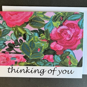 May include: A pink and green floral greeting card with the text "thinking of you" in black.