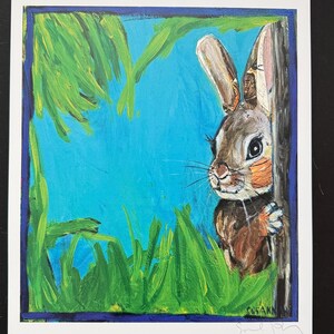 Op de afbeelding: Origineel schilderij van een bruin konijn dat achter een boom vandaan gluurt. Het kunstwerk heeft een blauwe achtergrond met groen gras en een blauwe rand. Het konijn heeft bruine en oranje vacht en lange oren. Gesigneerd door de kunstenaar.