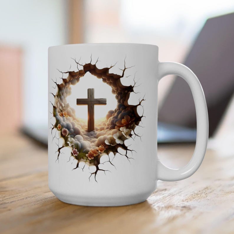 May include: White ceramic mug featuring a detailed graphic of a wooden cross set against a backdrop of clouds and flowers. The design is framed by a cracked, textured border. The mug has a large handle and is set on a wooden surface.