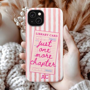 Puede incluir: Funda de tel&eacute;fono con rayas rosas y blancas. La funda presenta un dise&ntilde;o de tarjeta de biblioteca rosa con el texto "just one more chapter" en cursiva. Las iniciales "AC" est&aacute;n en la parte inferior.