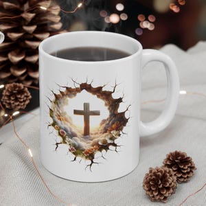 May include: White ceramic coffee mug featuring a cross design. The cross is set against a backdrop of clouds and flowers, framed by a cracked border. The mug has a curved handle and is filled with a dark liquid.