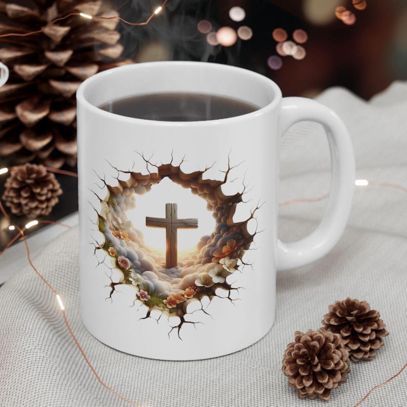 May include: White ceramic coffee mug featuring a cross design. The cross is set against a backdrop of clouds and flowers, framed by a cracked border. The mug has a curved handle and is filled with a dark liquid.
