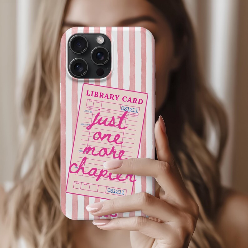 Puede incluir: Funda de tel&eacute;fono con un fondo de rayas rosas y blancas. Un gr&aacute;fico de tarjeta de biblioteca rosa est&aacute; superpuesto, con las palabras "Just one more chapter" en escritura rosa. La tarjeta de la biblioteca tambi&eacute;n tiene el texto "Library Card" y el n&uacute;mero "031211".
