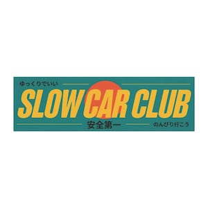 Könnte beinhalten: Rechteckiger Aufkleber mit dem Text "SLOW CAR CLUB" in Gelb, über einem roten Kreis, auf türkisfarbenem Hintergrund. Japanischer Text über und unter dem Haupttext.