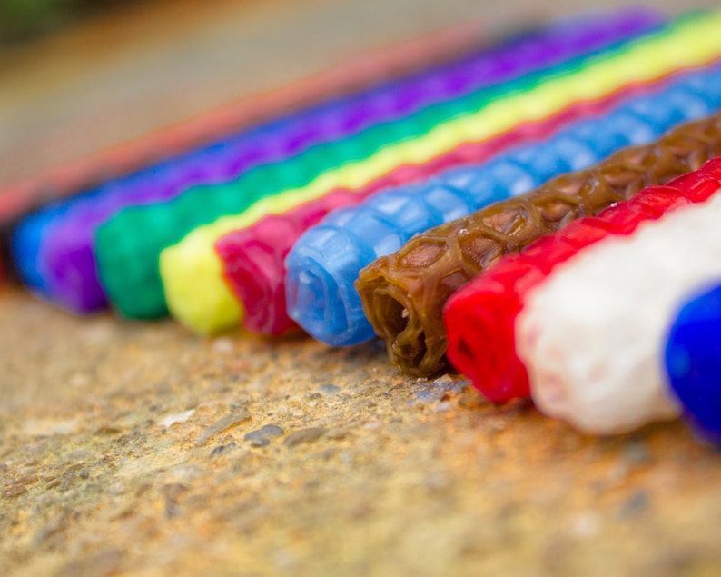 Candles of a variety of colors displayed to show their bottoms. Candles fit a standard Waldorf ring, and can also be used as birthday candles.