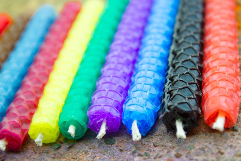 Candles of a variety of colors displayed to show the wicks. Wicks are approximately one quarter of an inch long.