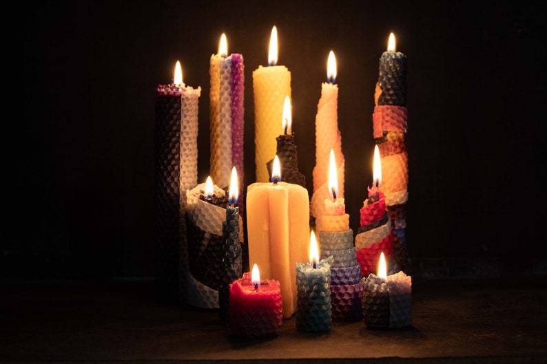 Image shows several lit beeswax candles. Beeswax burns cleanly, and smells like honey.