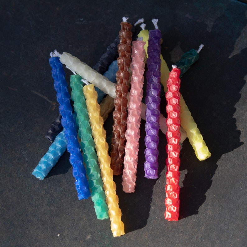 Image shows a pile of rolled beeswax birthday candles, showing the colors available.