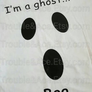 May include: White t-shirt with black text that reads "I'm a ghost... Boo.". The shirt has a ghost face with two black eyes and a mouth.
