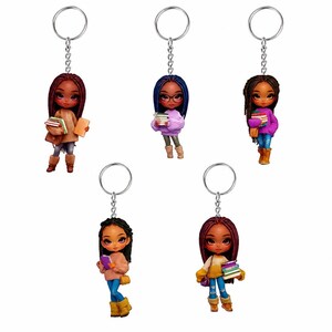 May include: Five keychains featuring stylized figures of individuals with diverse hair colors and clothing styles, each holding a stack of books. The figures have large eyes and are attached to silver-toned metal rings with short chains.