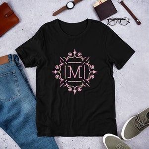 May include: Black t-shirt with a white letter "M" in a pink and green floral design.