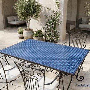 May include: A rectangular outdoor dining table with a blue and dark blue geometric mosaic tile top and a black wrought iron frame, accompanied by four matching black wrought iron chairs featuring white seat cushions and scrollwork details.