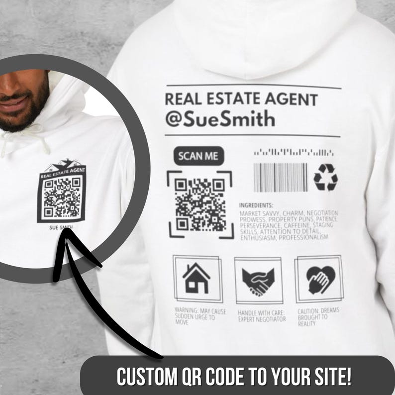 May include: White hoodie with a black and white QR code on the front and a black and white design on the back that says "REAL ESTATE AGENT @SueSmith" with a scan me QR code, a bar code, and a recycling symbol. The design also includes three icons: a house, a handshake, and a heart. The text "CUSTOM QR CODE TO YOUR SITE!" is at the bottom of the design.