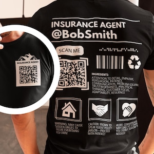 May include: Black t-shirt with a white design that says "Insurance Agent @BobSmith" and includes a QR code, a barcode, and a recycling symbol. The design also includes a house, a handshake, and a heart.