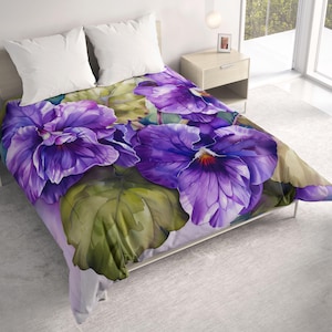 May include: A bed with a comforter featuring a large floral design. The comforter showcases oversized purple pansies with yellow centers and green leaves. Two white pillows are visible at the head of the bed.
